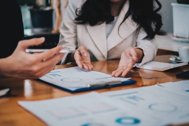 Bir grup Asyalı iş adamı yeni finansal projeyi analiz etmek ve planlamak için tartışıyor ve beyin fırtınası yapıyor.