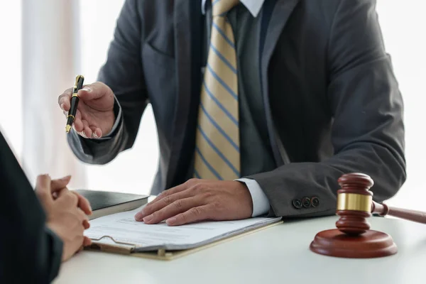 Donna d'affari e avvocati discutono documenti contrattuali con scala in ottone su scrivania in legno in ufficio. Diritto, servizi giuridici, consulenza, concetto di giustizia . — Foto Stock