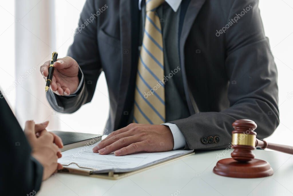 Business woman and lawyers discussing contract papers with brass scale on wooden desk in office. Law, legal services, advice, Justice concept.