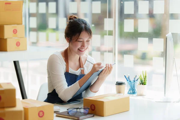 Asian small business owner with packing parcel box at home office, SME e commerce concept. — Foto de Stock