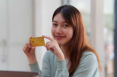 Çevrimiçi ödeme yapan ve kredi kartı tutan bir kadın. Çevrimiçi Alışveriş kavramı.