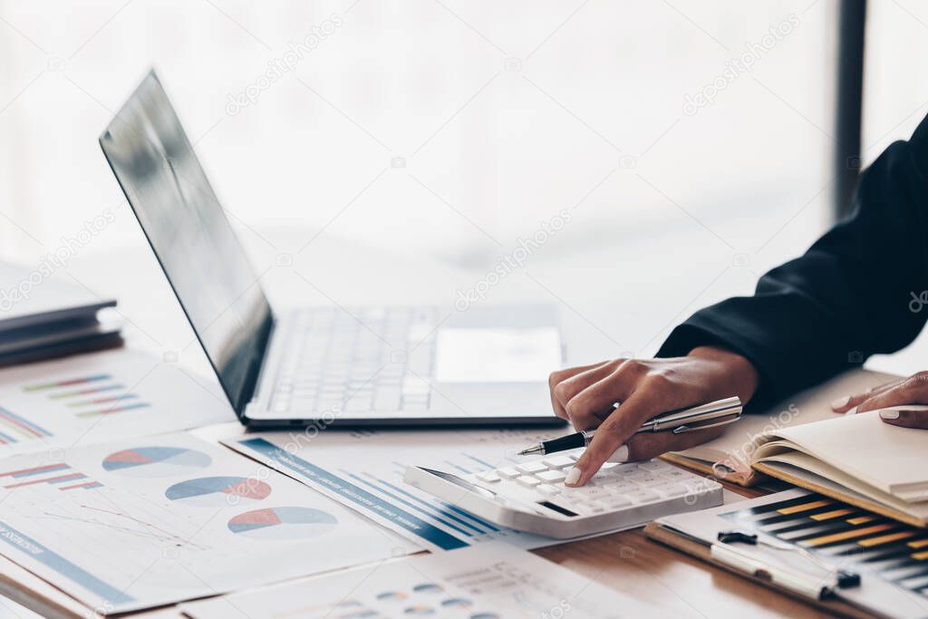 Close up Business woman hand using calculator to calculate the companys financial results and budget. Account Audit Concept.