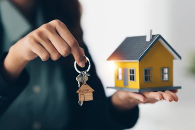 Ajanlar bize müşterilerin anahtarlarını veriyor ve ajans ofisinde dolarları tutuyorlar. Anlaşma ve Emlak Konsepti.