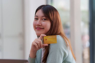 Çevrimiçi ödeme yapan ve kredi kartı tutan bir kadın. Çevrimiçi Alışveriş kavramı.