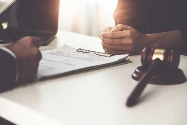 Geschäftsfrau und Juristen diskutieren im Büro auf einem Holztisch mit Messingwaage über Vertragspapiere. Recht, Rechtsdienstleistungen, Beratung, Gerechtigkeitskonzept. — Stockfoto