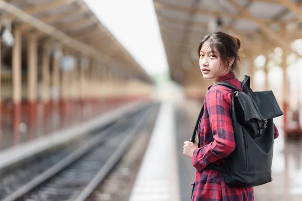 Young traveler woman looking for friend planning trip at train station. Summer and travel lifestyle concept. — Stockfoto