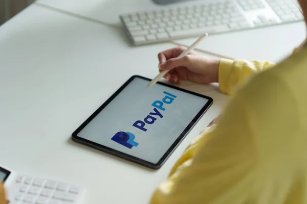 CHIANG MAI, THAILAND - MUNGKIN 11 2022: Perempuan menggunakan Ipad dengan logo paypal di layar. PayPal adalah sistem pembayaran online di seluruh dunia dan salah satu cara yang paling populer untuk melakukan pembayaran di Internet. — Stok Foto