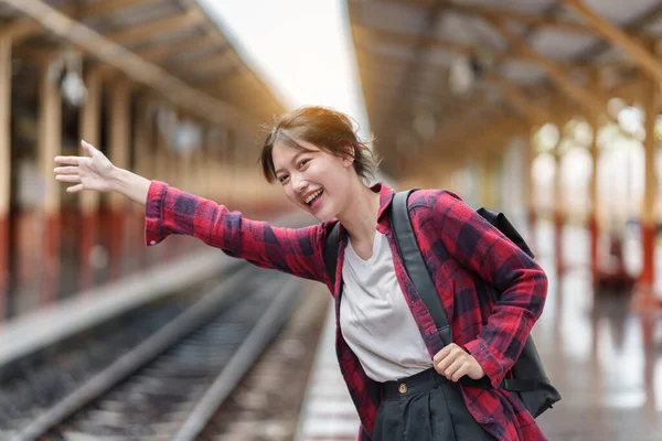 Mooie jonge reiziger vrouw opgewonden en planning reis op het station. Zomer en reizen levensstijl concept. — Stockfoto