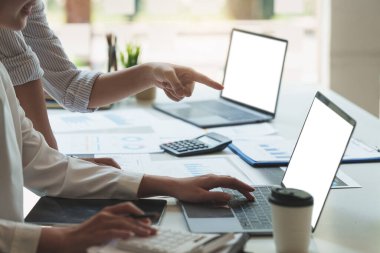 Analitik istihbarat konsepti. İş adamları grubu, toplantıda yatırım için dizüstü bilgisayarda mevcut mali ve ekonomik konuları tartışıyor..