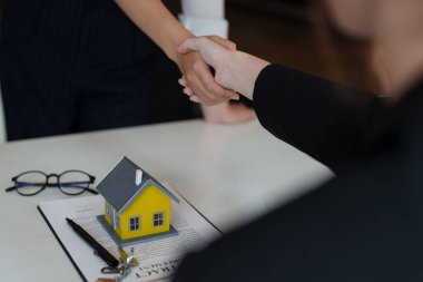 Müşteri bir ev satın almak için bir sözleşme imzaladıktan sonra harika bir pazarlık alır. Komisyoncu ve müşteri iyi bir anlaşma yaptıktan sonra el sıkışırlar. Emlak kavramı.