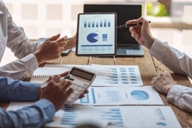 Dijital tablet ve yönetimle çalışan bir grup bilişim danışmanı büyük veriler elde ediyor ve şirketin mali belgelerini analiz ediyor.