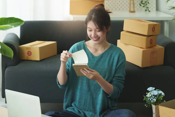 Online μάρκετινγκ συσκευασίας κουτί παράδοσης έννοια. Ασιατική γυναίκα startup μικρή επιχείρηση freelance με κουτί δεμάτων για παράδοση στον πελάτη. — Φωτογραφία Αρχείου
