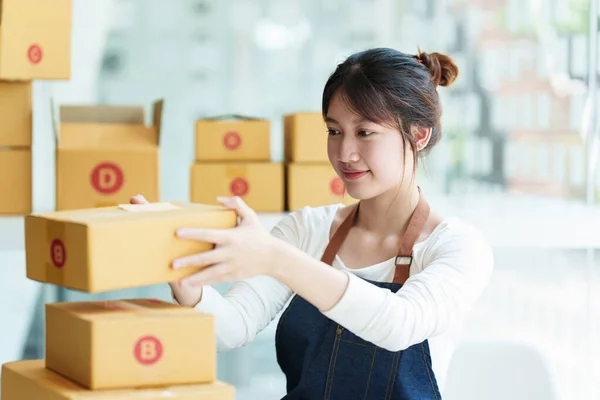 Joven asiático freelance cajas de embalaje para comercial. Concepto de comercio electrónico PYME. — Foto de Stock