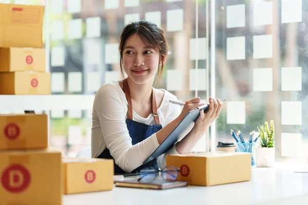 Young asian freelance packing boxes for commercial. SME e commerce concept. — Foto de Stock