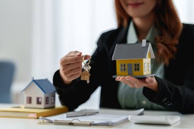 Ajanlar bize müşterilerin anahtarlarını veriyor ve ajans ofisinde dolarları tutuyorlar. Anlaşma ve Emlak Konsepti.