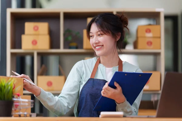 A portrait of Asian woman, e-commerce employ.e freelance with parcel box for deliver to customer. Online marketing packing box delivery concept. — Foto de Stock