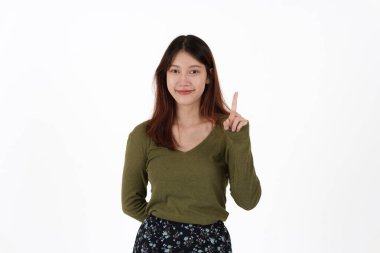 Ayakta duran ve beyaz arka planda izole edilmiş kamerayı gösteren mutlu genç kız görüntüsü.