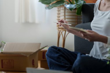 Asyalı küçük işletme sahibi ev ofisinde çalışıyor. Ticari perakende pazarı ve çevrimiçi pazarlama dağıtımı, KOBİ e-ticaret kavramı.