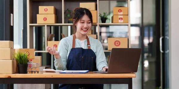 Un retrato de mujer asiática, empleado de comercio electrónico freelance con caja de paquetes para entregar al cliente. concepto de entrega de caja de embalaje de marketing en línea. — Foto de Stock