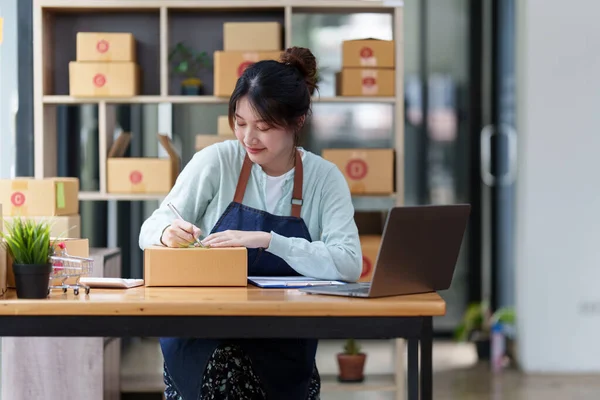 Un retrato de mujer asiática, empleado de comercio electrónico freelance con caja de paquetes para entregar al cliente. concepto de entrega de caja de embalaje de marketing en línea. — Foto de Stock