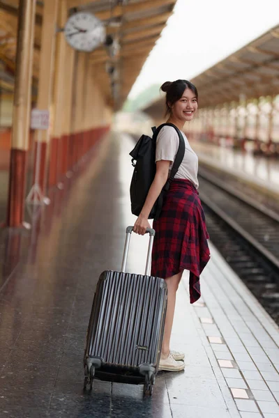 Jonge reiziger vrouw die een reis plant op het station. Zomer en reizen levensstijl concept. — Stockfoto
