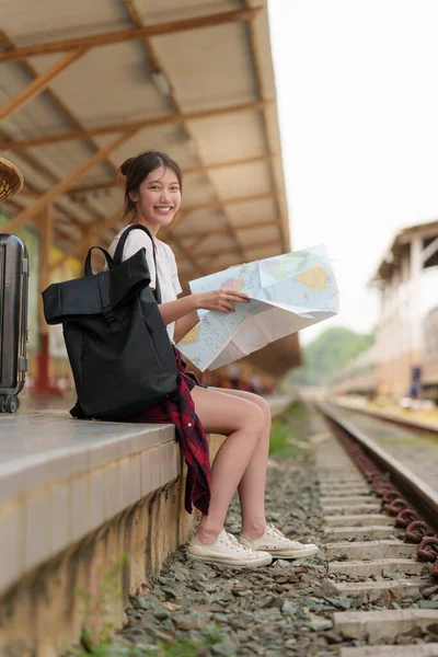 Jonge reiziger vrouw op zoek naar kaarten planning reis op het station. Zomer en reizen levensstijl concept. — Stockfoto