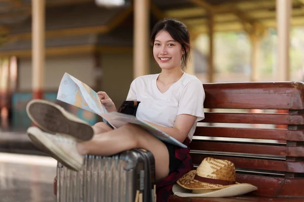 Jonge reiziger vrouw op zoek naar kaarten planning reis op het station. Zomer en reizen levensstijl concept. — Stockfoto