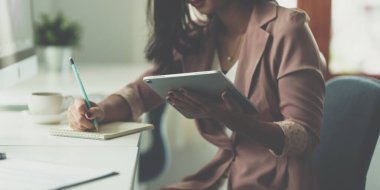 İş kadını ofiste dijital tablet kullanıyor, hesap veya tasarruf veya sigorta kavramı kullanıyor.