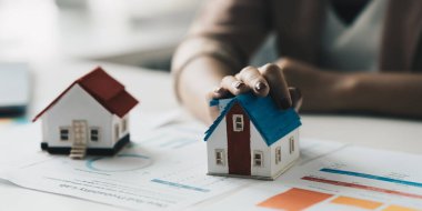 Close up of Business woman choosing house after signing agreement for buying house. Bank manager concept.