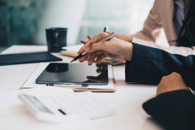 Dijital tablet ve yönetimle çalışan bir grup bilişim danışmanı büyük veriler elde ediyor ve şirketin mali belgelerini analiz ediyor.