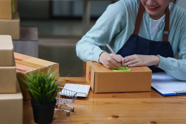 Online marketing packing box delivery concept. Asian Woman startup small business freelance with parcel box for deliver to customer. — Stockfoto