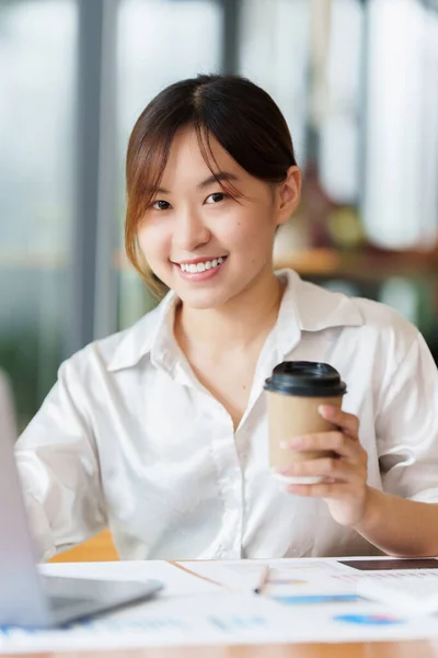 Portrait of Business woman hand holding coffee and analyze financial by laptop. Account and Finance concept. — 스톡 사진