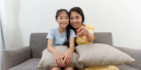 Emocionado joven madre asiática y niña viendo programas de televisión. Estilo de vida y pasa el ocio en casa. — Foto de Stock