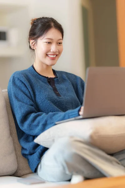 Porträtt av ung asiatisk kvinna med hjälp av sociala medier med bärbar dator. Livsstil, Shopping online, koppla av på soffan. — Stockfoto