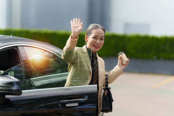 アジアシニアビジネス女性の肖像画は オフィスに来ている間に高級車を出てステップ 勘定及び財務の概念 — ストック写真