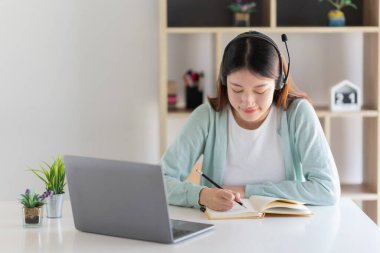 E-öğrenme, çevrimiçi, eğitim ve internet sosyal mesafesi COVID-19 virüs kavramından korunuyor. Asyalı kadın öğrenci video konferansı evde dizüstü bilgisayarda öğretmenle e-öğrenme