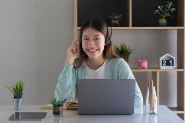 E-öğrenme, çevrimiçi, eğitim ve internet sosyal mesafesi COVID-19 virüs kavramından korunuyor. Asyalı kadın öğrenci video konferansı evde dizüstü bilgisayarda öğretmenle e-öğrenme