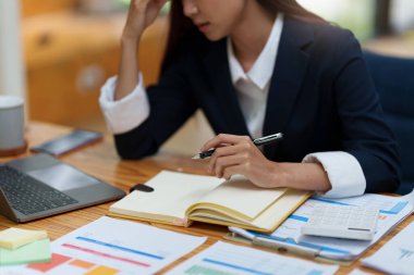 Asyalı iş kadını portresi, bu yılın pazarlama planı hakkında müşteriyle konuşurken endişelenir.