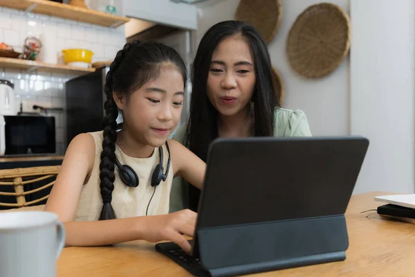 家庭和家庭学校的概念 亚洲母亲在家里教女儿使用数码平板电脑 — 图库照片