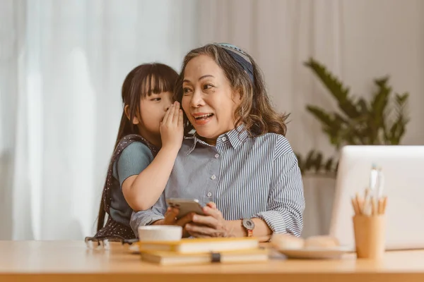 当亚洲资深女商人在家里工作时 孙女的快乐时刻给了她拥抱 家庭概念 — 图库照片