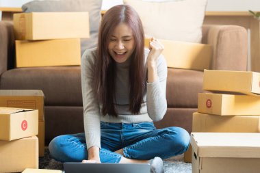 Asyalı küçük işletme sahibi ev ofisinde çalışıyor. Ticari perakende pazarı ve çevrimiçi pazarlama dağıtımı, KOBİ e-ticaret kavramı