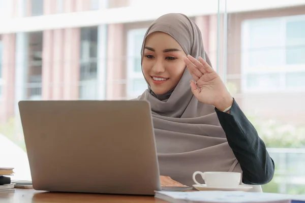 Portrait of happy asian beautiful girl making video calling with laptop and waving on phone screen at home. job interview remotely concept