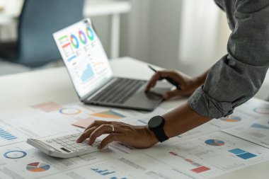 Finansal konsepte danış. İşadamı kadın evrak işleriyle ilgileniyor ve ofiste hesap makinesi kullanıyor. Ofise dön.