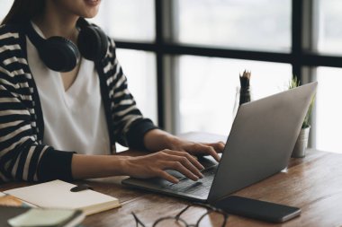 İnternetteki webinarlara odaklanan bir kadın. İnternet dersinde kulaklık takan öğrenci.