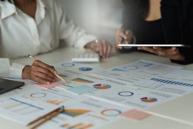 İş yerinde çalışan bir grup iş adamı. İş adamları mali planlama, toplantı, tartışma ve çalışma masasında tabletle beyin fırtınası yapıyor.