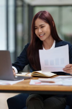 Finansal konsepte danış. İşadamı kadın evrak işleriyle ilgileniyor ve ofiste hesap makinesi kullanıyor. Ofise dön.