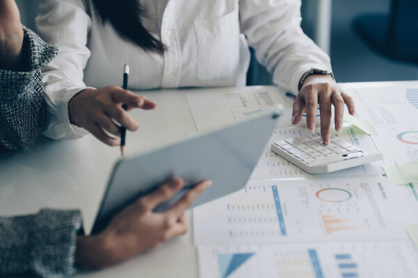 Группа ИТ-консультантов, работающих по цифровым планшетам и управлению большими данными и анализирующих финансовый документ компании