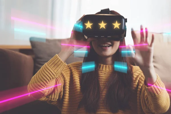 Exciting asian woman with wearable VR headset playing sport gaming online in living room at home