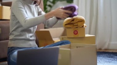 Asyalı küçük işletme sahibi ev ofisinde çalışıyor. Ticari perakende pazarı ve çevrimiçi pazarlama dağıtımı, KOBİ e-ticaret kavramı