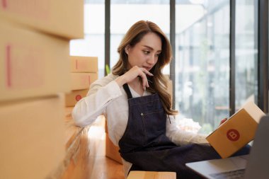 Girişimci KOBİ 'ye teslim etmek üzere depodaki genç Asyalı kadın. İş dijital çevrimiçi KOBİ küçük işletme ve çevrimiçi dükkan